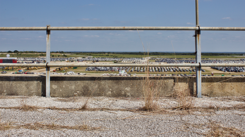 Texas World Speedway in 2017, dead weeds creeping through what used to be part of the grandstands, as flood cars were just beginning to arrive at the track.
